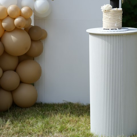 A graduation party table with balloons and cake
